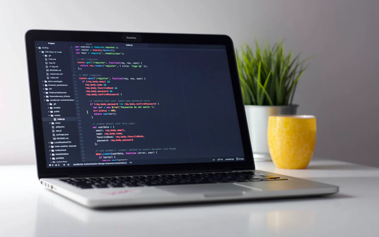 Bærbar computer på et skrivebord med JavaScript-kode i en editor