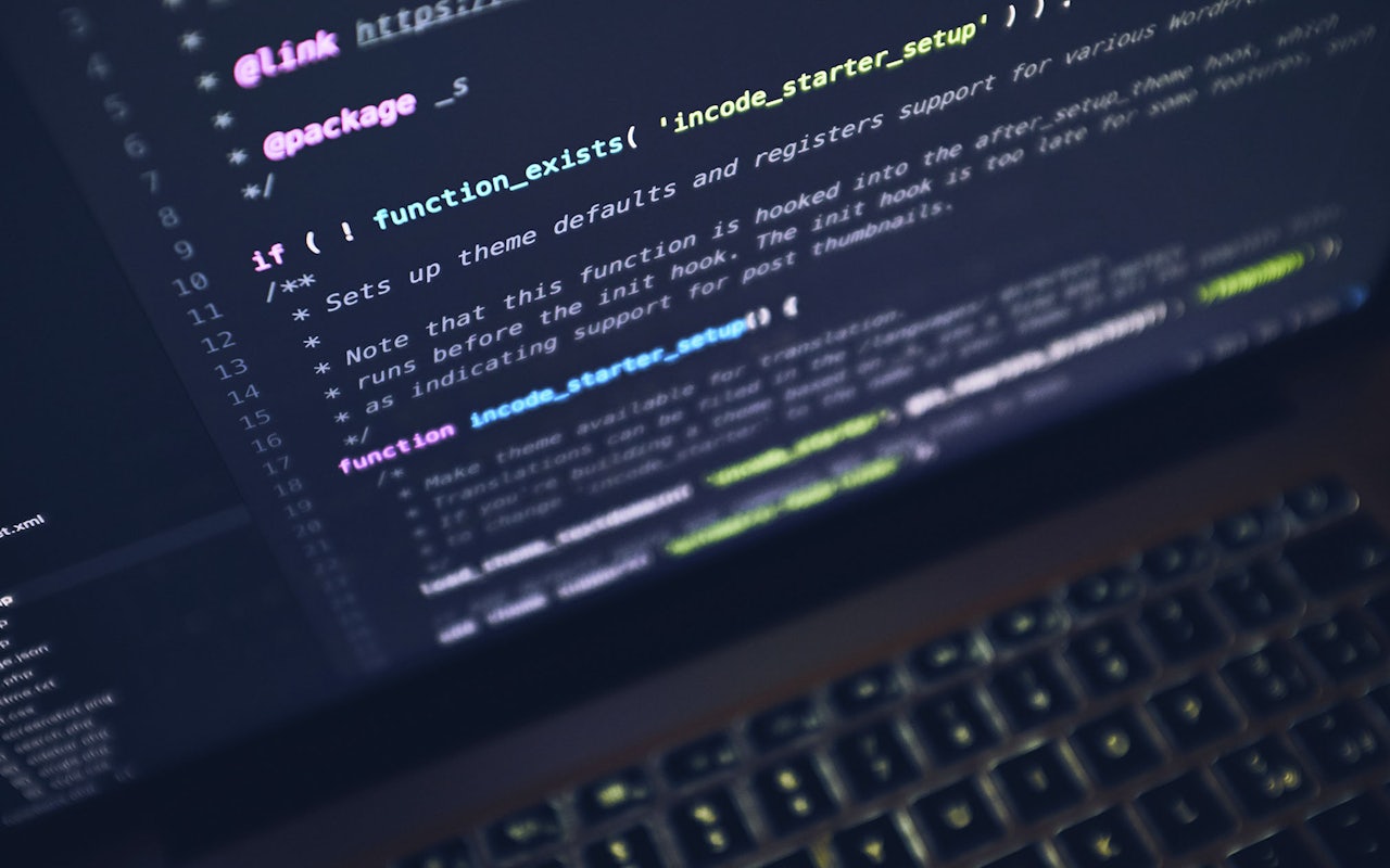 Kildekode på skærmen af en bærbar computer i et svagt oplyst rum