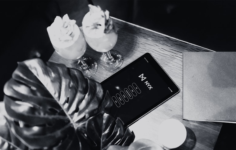 iPad with Nyx installed and drinks on a table in a nightclub